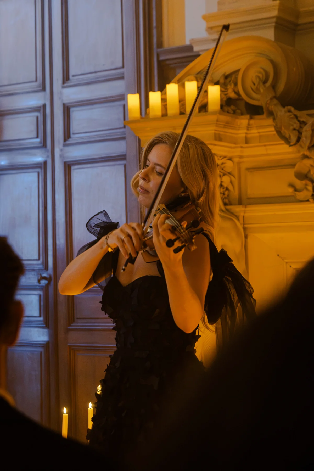 Anastasia joue devant une cheminée illuminée de bougies